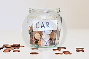 Car loan, car insurance concept. Glass jar full of coins and paper sign car