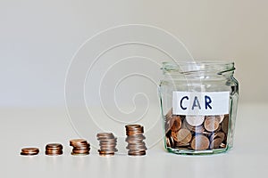 Car loan, car insurance concept. Glass jar full of coins and sign car