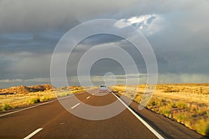 Car on a long road to the sky horizon