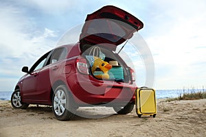 Car with luggage on beach. Summer vacation trip