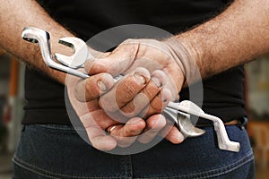 Car mecanic holding his tools in a car repair shop.