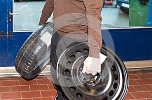 Car mechanic carries the wheels and changes the car tires - Serie Repair Workshop