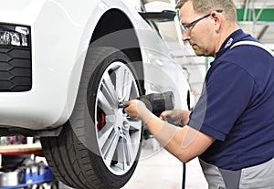 Car mechanic changes the tires of the vehicle in the workshop