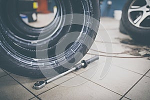 Car mechanic changind tires of a car in a repair shop car garage