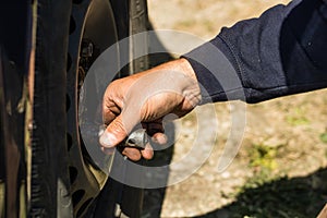 Car mechanic changing car wheel and tire by wrench at car garage in Bucharest, Romania, 2021