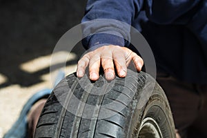 Car mechanic changing car wheel and tire by wrench at car garage in Bucharest, Romania, 2021