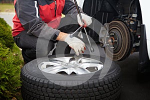 Car mechanic changing tire.