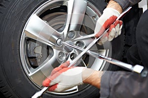 Car mechanic changing tire.