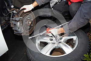 Car mechanic changing tire.