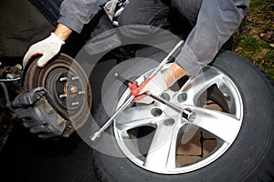 Car mechanic changing tire.