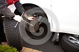 Car mechanic changing tire.