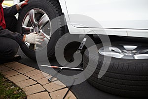 Car mechanic changing tire.