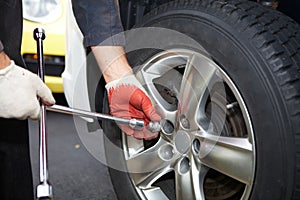 Car mechanic changing tire. photo