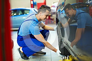 Car mechanic changing tires