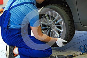 Car mechanic changing tires