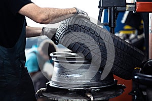 Car mechanic changing tires of a car in a repair shop