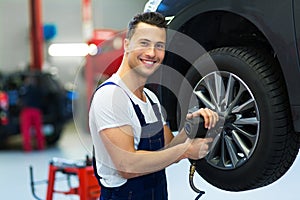 Car mechanic changing tires photo