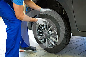 Car mechanic changing tires photo