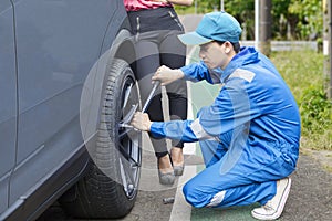 Car mechanic changing a tyre on the road