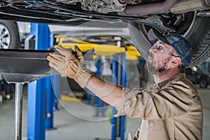 Car Mechanic Changing Vehicle Engine Oil