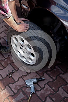 Car mechanic changing wheel