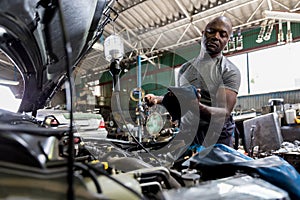 Car mechanic checking  oil quality the engine motor car Transmission and Maintenance Gear. car mechanic in an auto repair shop is