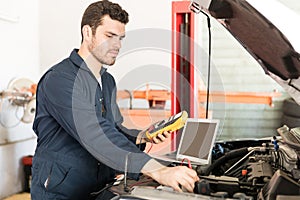 Car Mechanic Checking The Voltage Of Battery Using Voltmeter