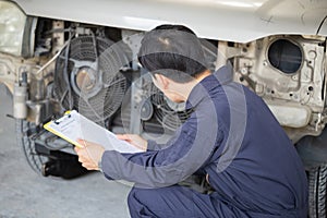 Car mechanic with a checklist, Technician checking modern car at garage, Car repair and maintenance concepts