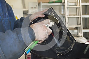 A car mechanic cleans the automatic transmission pan