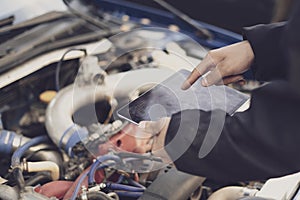 a car mechanic doing auto diagnostic using computer, searching for check engine