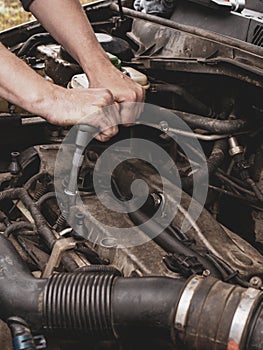 Car mechanic in garage with car engine, Auto service. The master changes auto parts