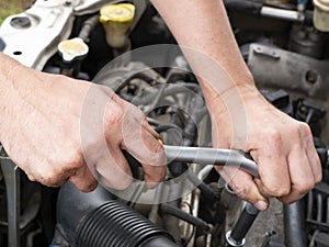 Car mechanic in garage with car engine, Auto service. The master changes auto parts