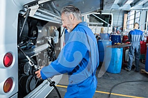 Car mechanic at garage checking car