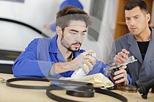 Car mechanic in garage oilinng engine gasket