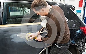 Car mechanic grinds a car part in handicraft in a service station - Serie car repair workshop