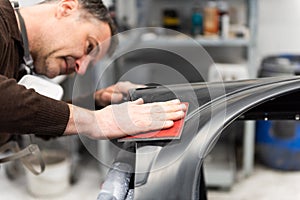 Car mechanic grinds a car part in handicraft in a service station - Serie car repair workshop