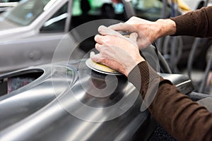 Car mechanic grinds a car part in handicraft in a service station - Serie car repair workshop