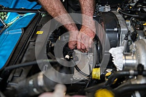 Car mechanic hands replacing intercooler on a car engine.