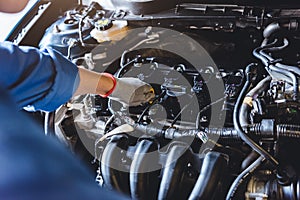 Car mechanic holding checking gear oil to maintenance vehicle by customer claim order in auto repair shop garage. Engine repair