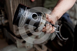 Car mechanic holding piston