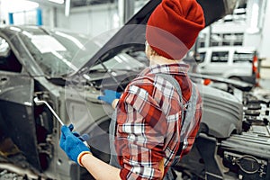 Car mechanic holding a wrench in her hands