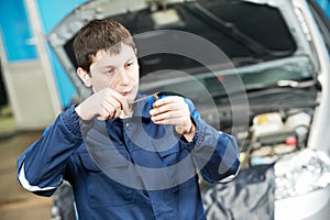 Car mechanic inspecting engine sparking plug