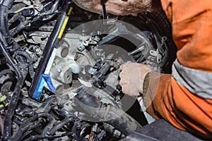 A car mechanic inspects a car faults and makes repairs in a car repair shop