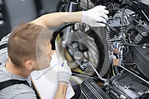 Car mechanic inspects motorcycle breakdowns in car repair shop