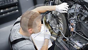 Car mechanic inspects motorcycle breakdowns in car repair shop