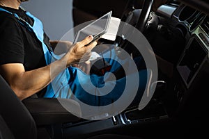 Car mechanic maintains the vehicle with the help of diagnostic modern computer equipment. Car service manager uses