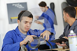 car mechanic man at garage fixing engine