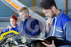 car mechanic man thinking at garage fixing engine