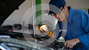 Car mechanic performing repair job at garage and car maintenance service station