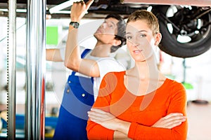 Car Mechanic repairing auto of woman customer